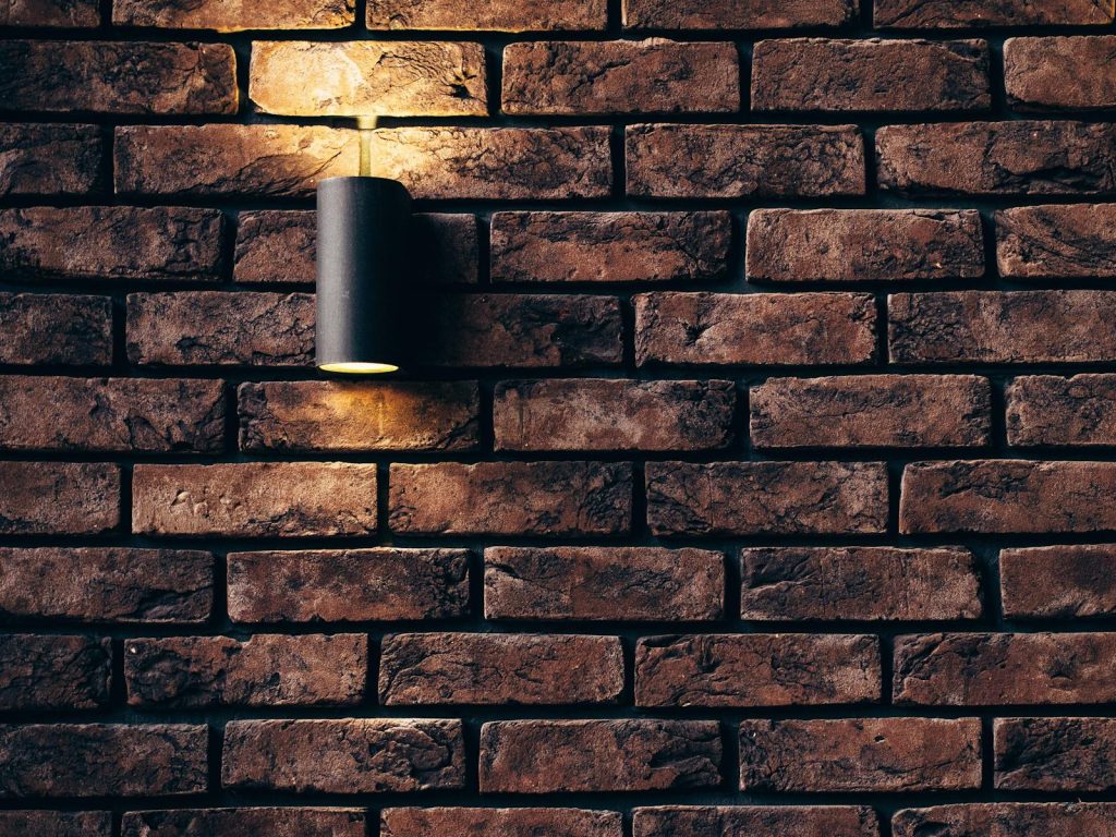 Installasjon av lyspunkt. Contemporary brick wall design featuring a sleek accent light. Lampe, lyspunkt, installering