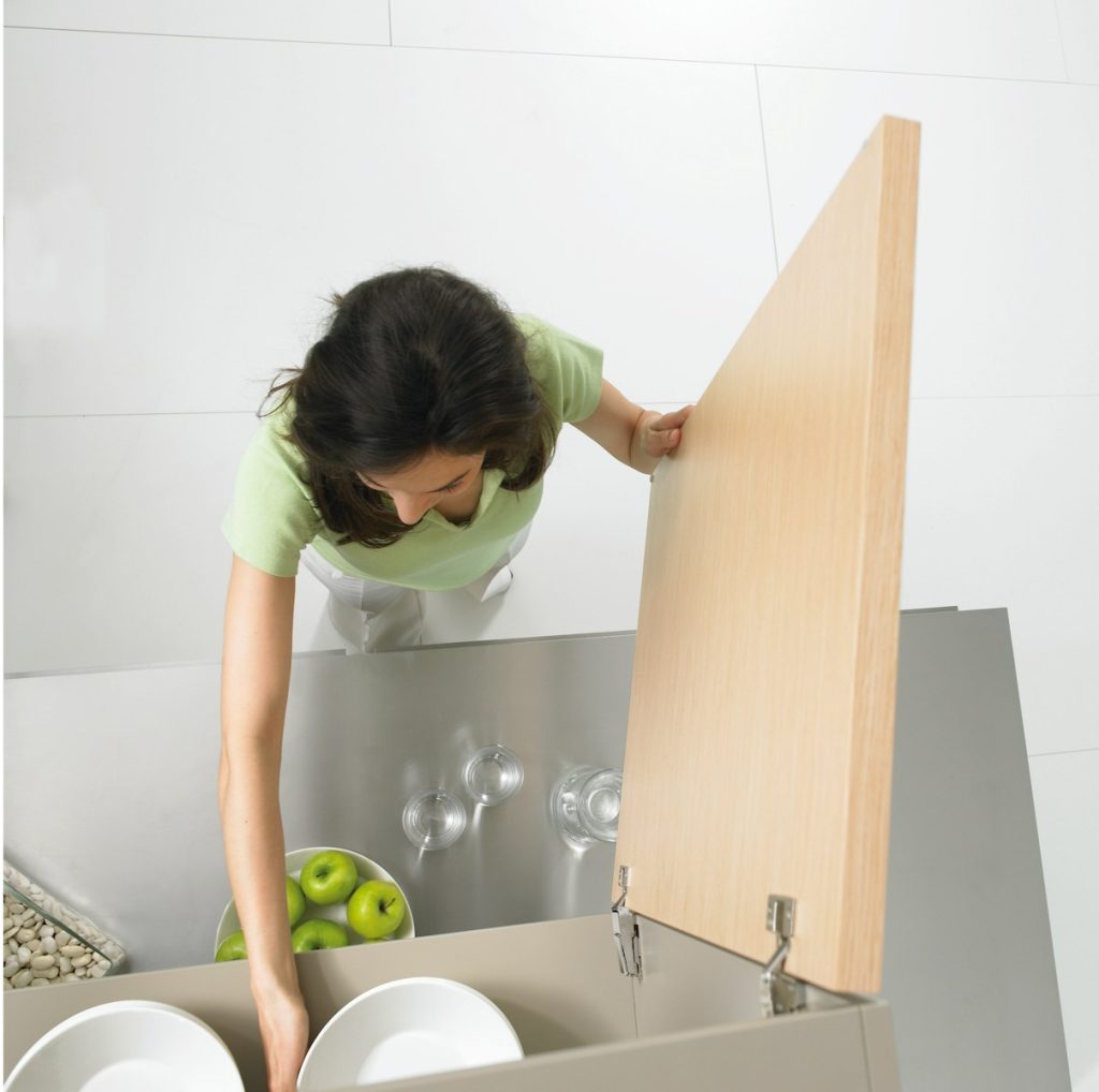 woman in green polo shirt and white pants standing in front of open cupboard, vaskehjelp priser, hva koster vaskehjelp, renholdstjenester, vasketjenester, privat vaskehjelp