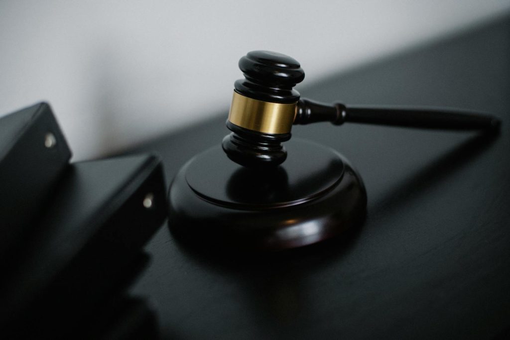 Close-up of a wooden gavel on a desk, symbolizing justice and legal authority. priser på juridiske tjenester