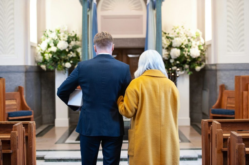 a man and a woman standing in front of a church begravelse, begravelseskostnad, begravelse, pris på begravelse