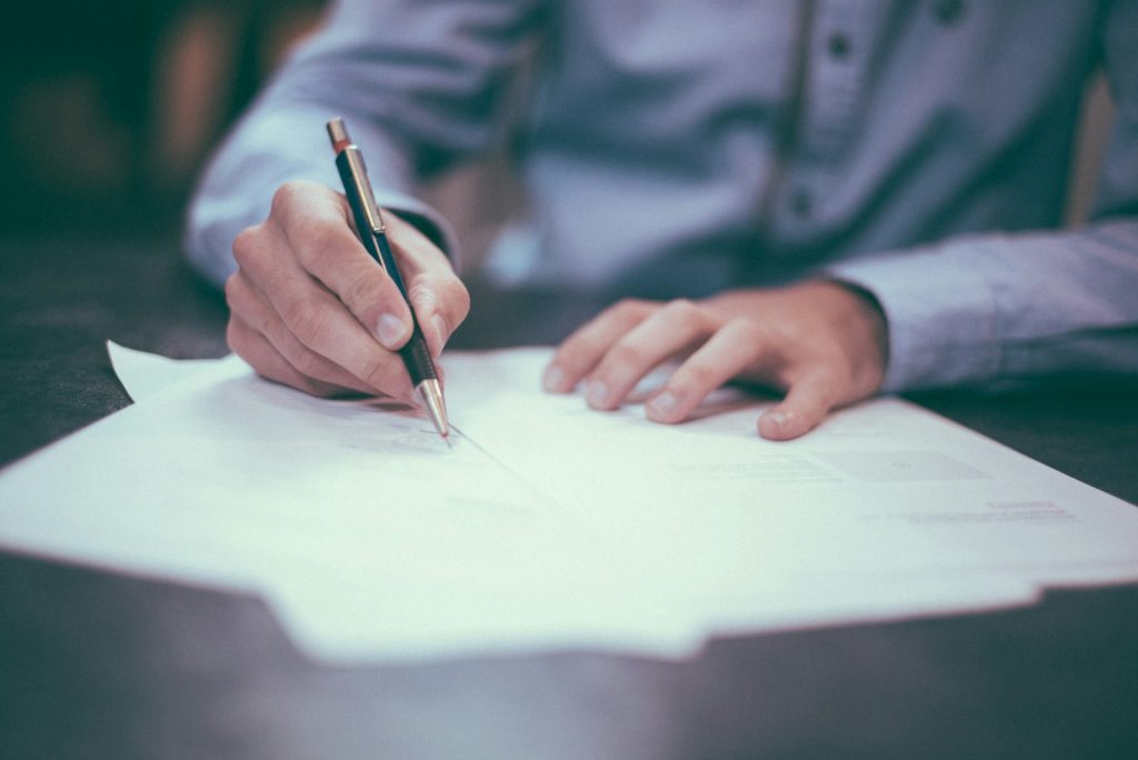 man writing on paper, advokat,Pris for opprettelse av testamente