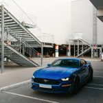 a blue sports car parked in front of a building