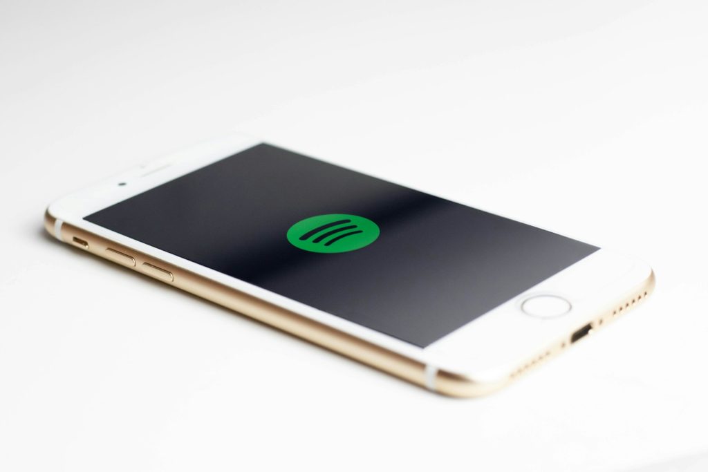 gold iPhone 7 displaying spotify logo, spotify